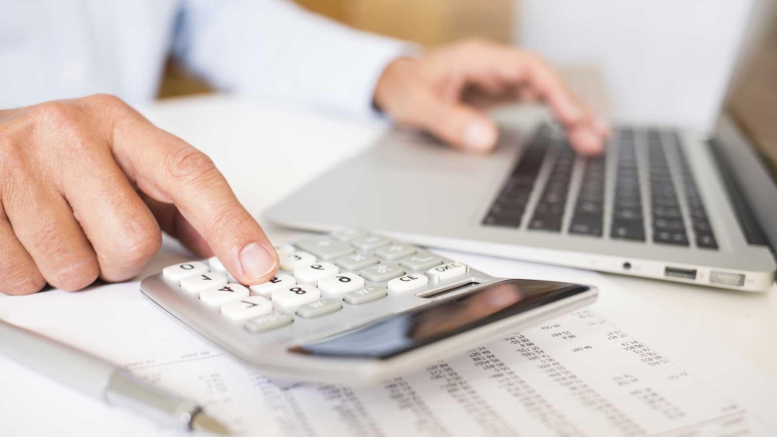 man using calcualtor pad and notepad screen