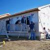 Students siding exterior of a home.